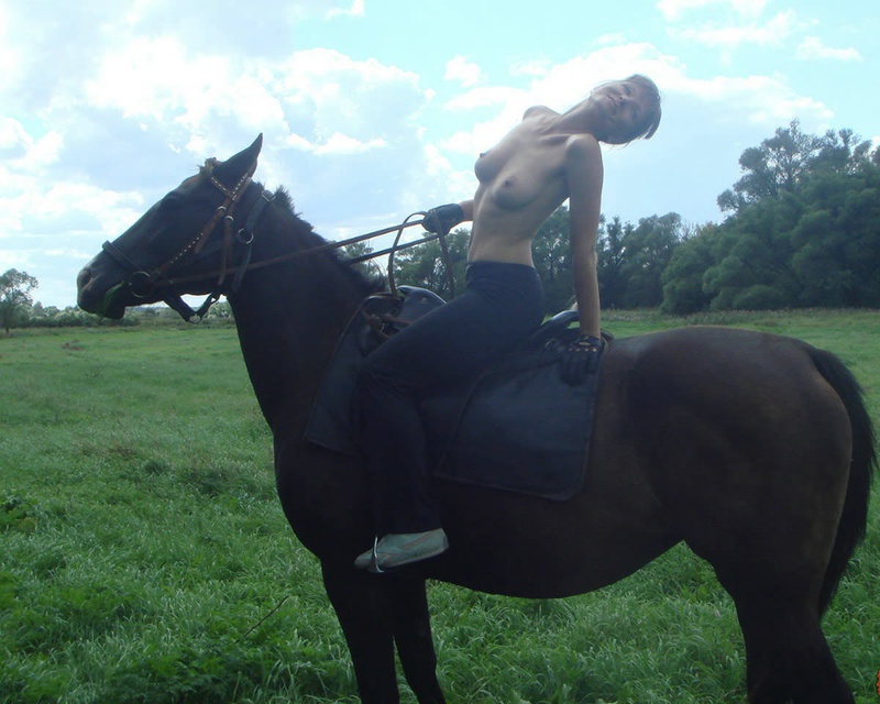Girl posing topless on a horse among the field 11 photo