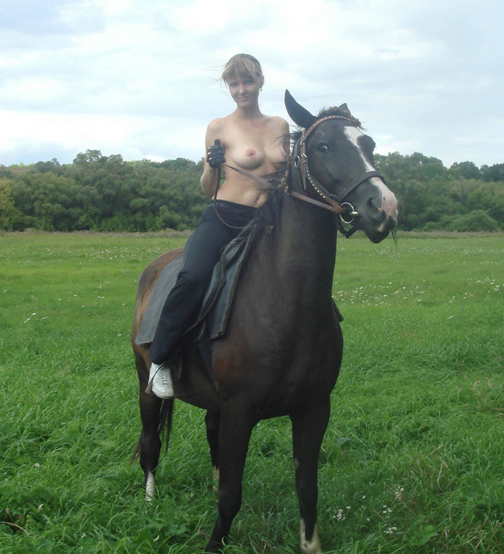 Girl posing topless on a horse among the field 9 photo