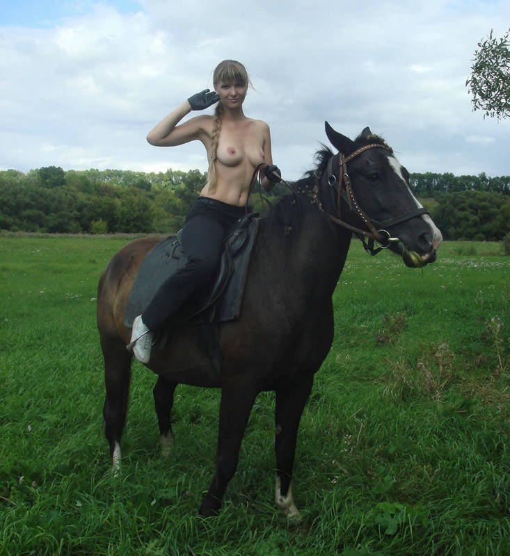 Girl posing topless on a horse among the field 16 photo