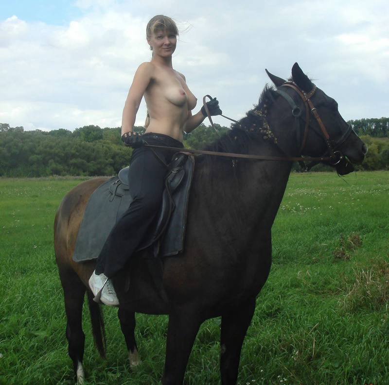 Girl posing topless on a horse among the field 8 photo