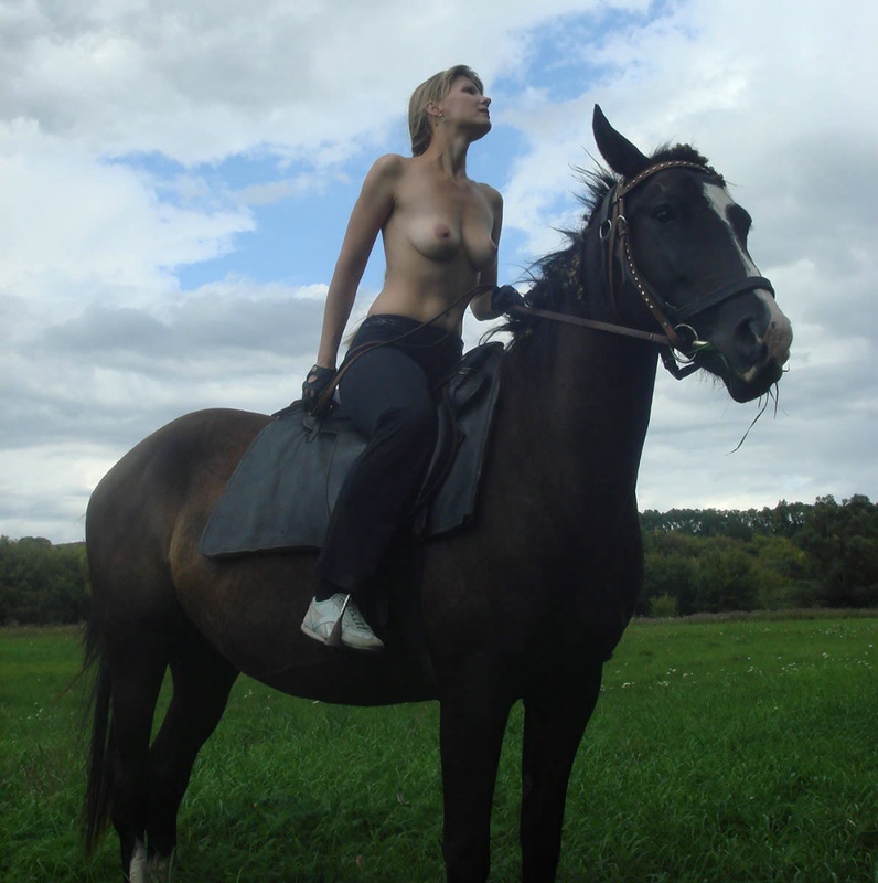Girl posing topless on a horse among the field 7 photo