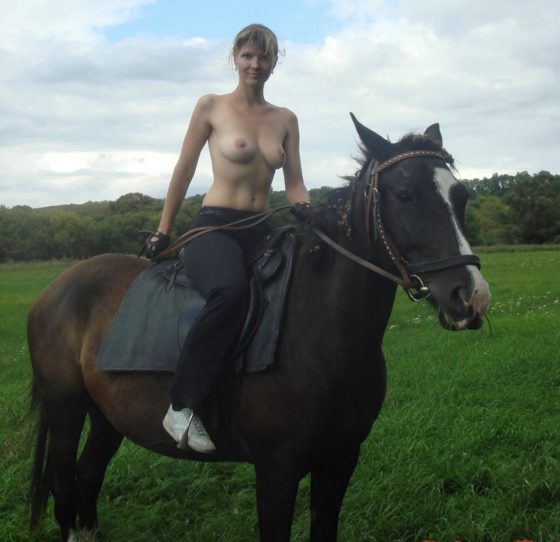 Girl posing topless on a horse among the field 6 photo